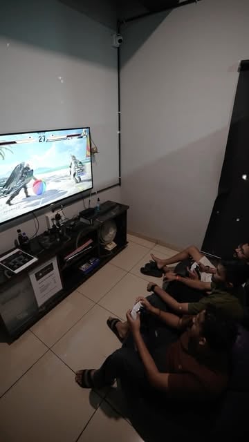 Two players seated on the floor playing on the PS5